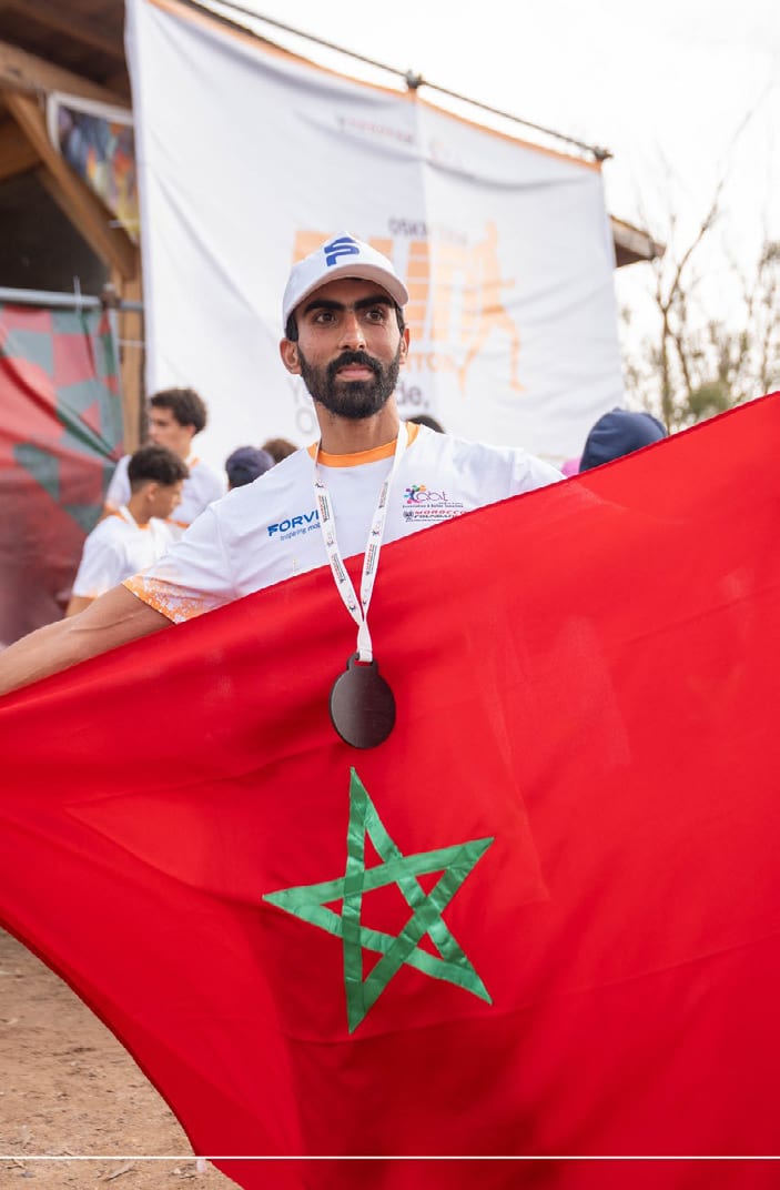 A runner carrying the Moroccan flag after finishing